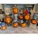 A collection of gourd characters. Each one has a different facial expression and hat. Each gourd has a unique name and it's own candle.
